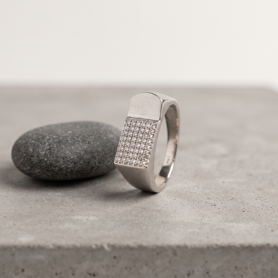 Silver ring with a rectangular pavé-set face and wide polished band.