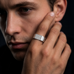Silver ring with a rectangular pavé-set face and wide polished band.