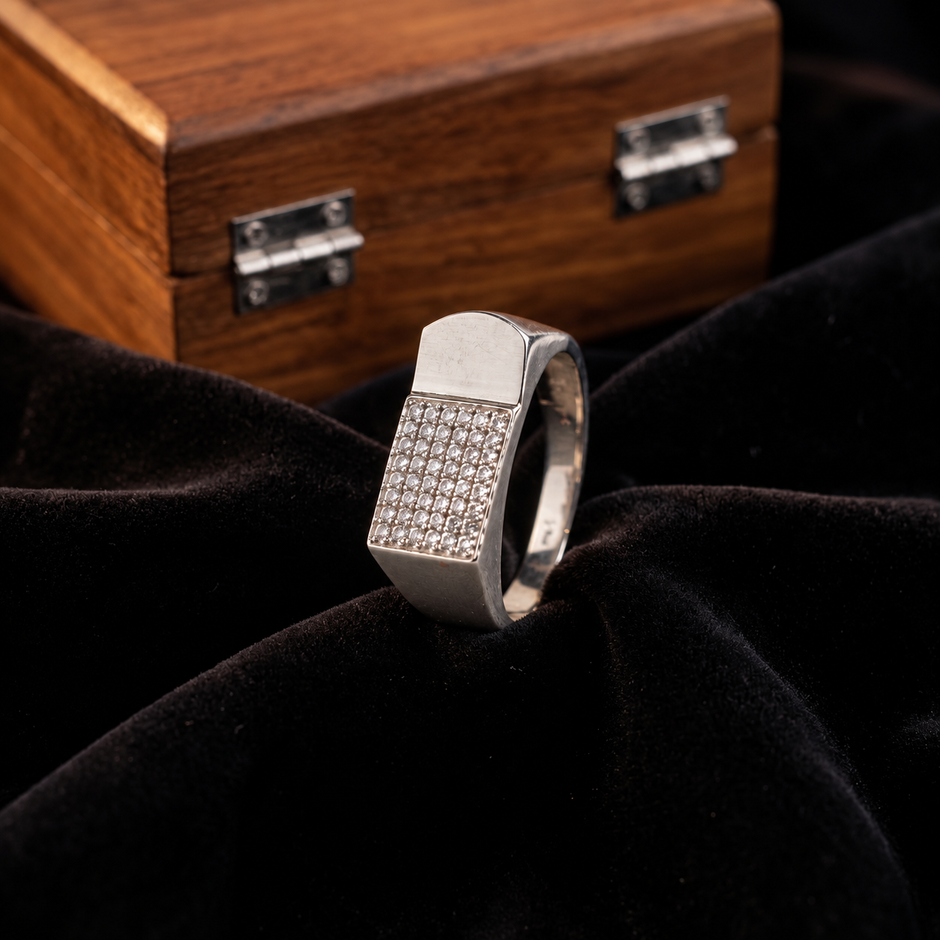 Silver ring with a rectangular pavé-set face and wide polished band.