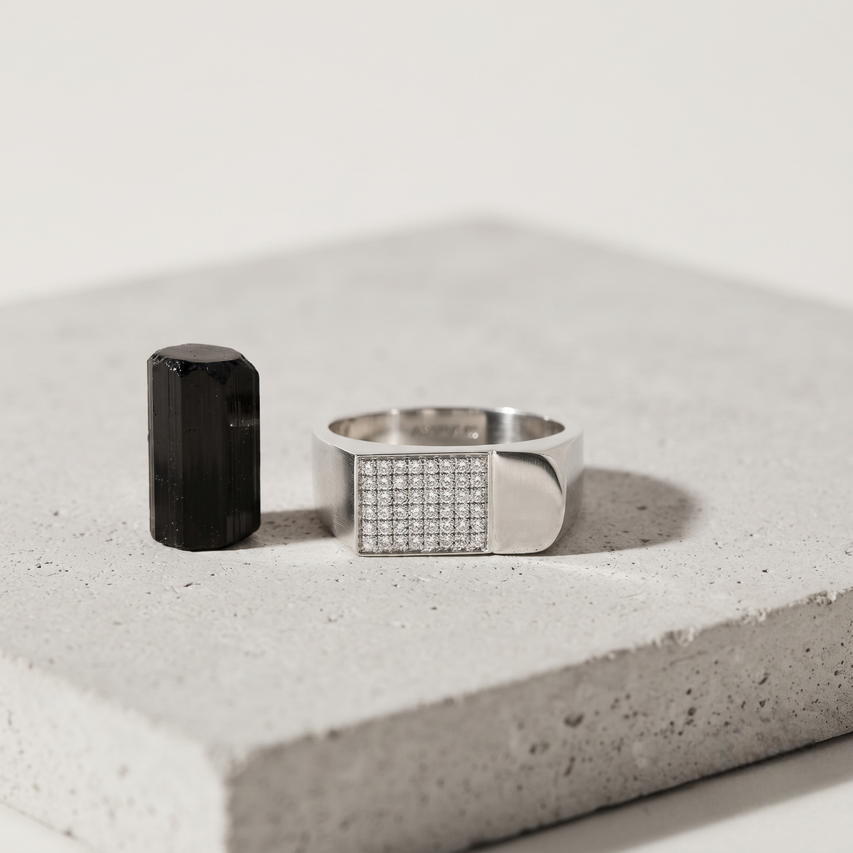 Silver ring with a rectangular pavé-set face and wide polished band.