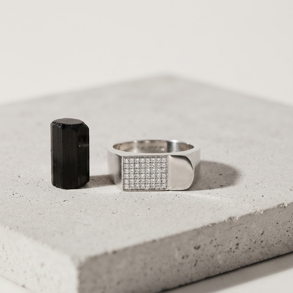 Silver ring with a rectangular pavé-set face and wide polished band.