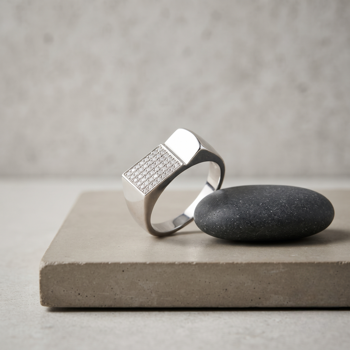 Silver ring with a rectangular pavé-set face and wide polished band.