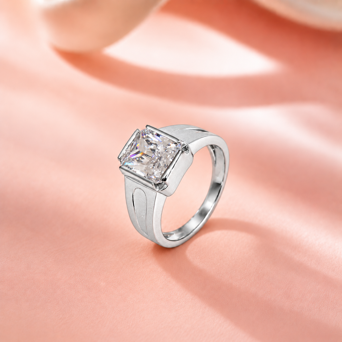 Silver ring with a large rectangular clear stone and engraved geometric band.