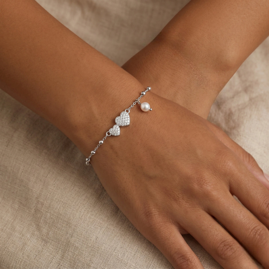 925 Sterling Silver Bracelet with Double CZ Heart Charms, Pearl Drop, and Beaded Chain on White Background