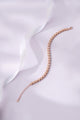 Rose gold bracelet on a soft white fabric background