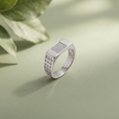 Silver ring with a rectangular stone-studded face and square lattice cutout band.