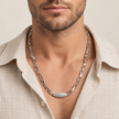 Silver paperclip chain with an oval stone-studded centrepiece.