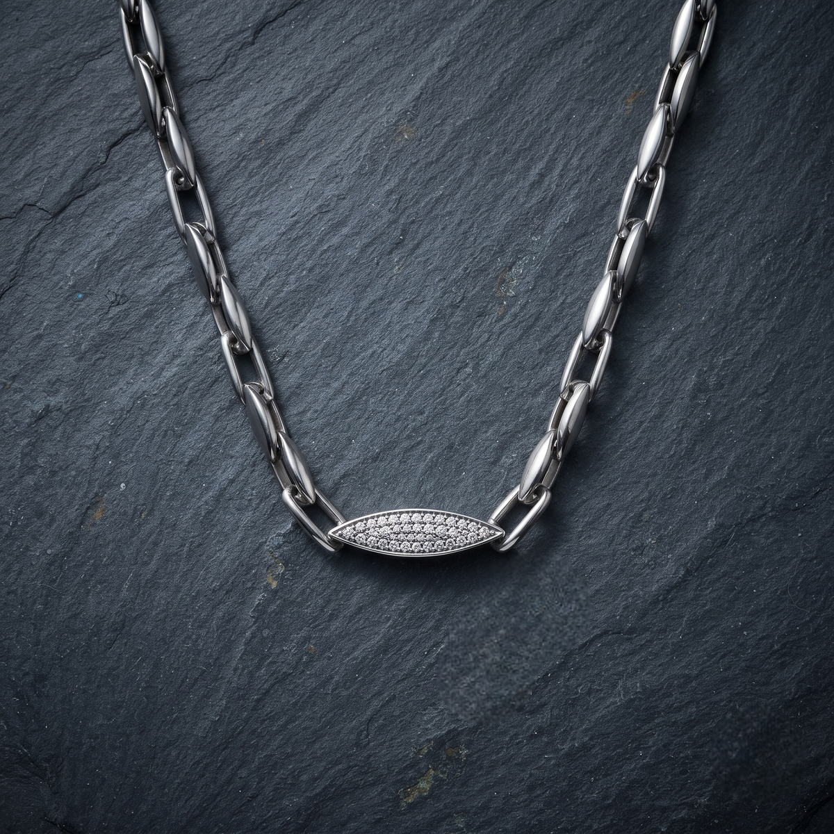 Silver paperclip chain with an oval stone-studded centrepiece.
