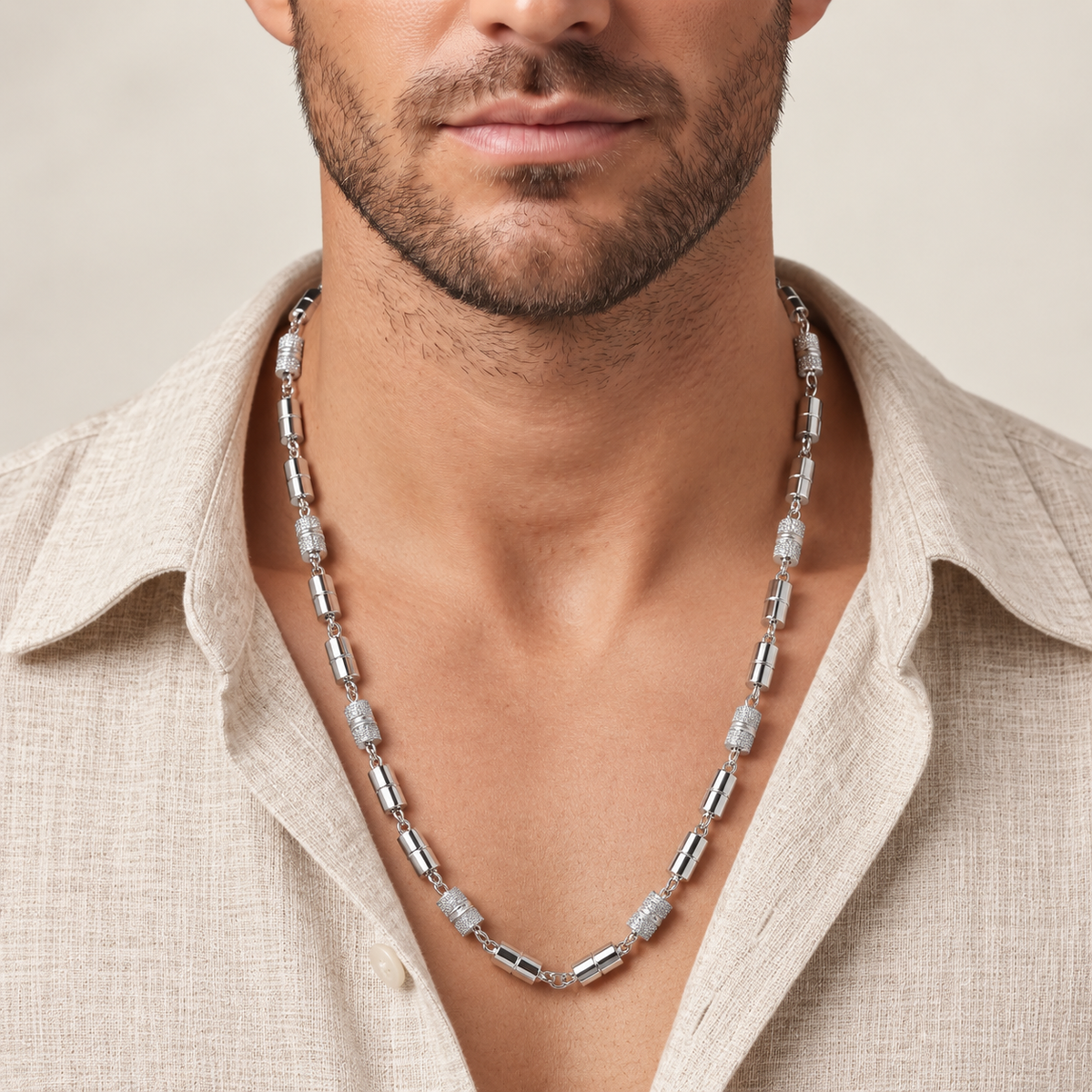 Silver chain with alternating polished cylindrical links and stone-studded barrel accents.