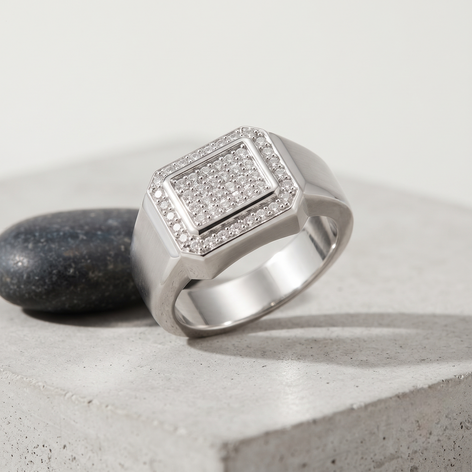 Silver ring with a square pavé-set centre, stone-studded halo and wide polished band.