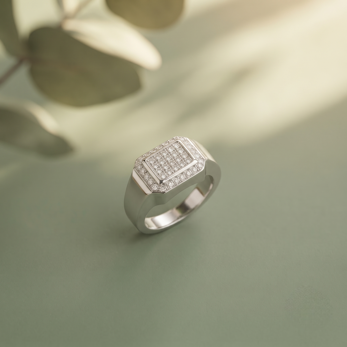 Silver ring with a square pavé-set centre, stone-studded halo and wide polished band.