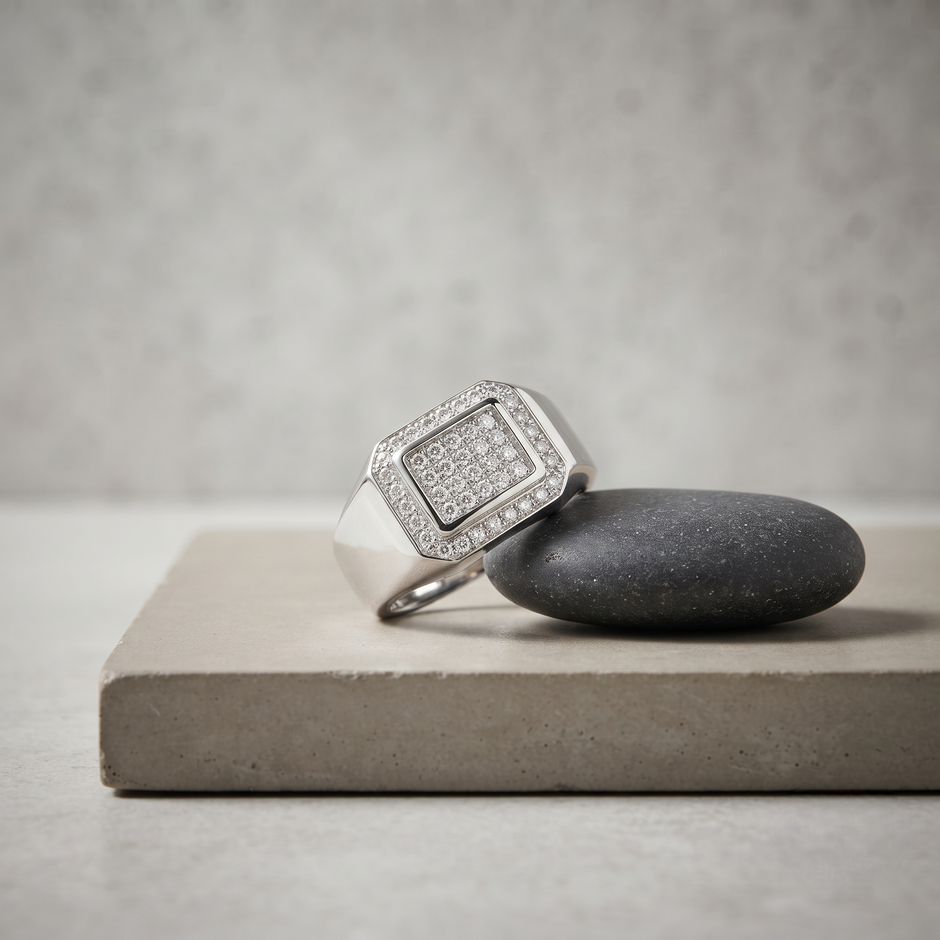 Silver ring with a square pavé-set centre, stone-studded halo and wide polished band.