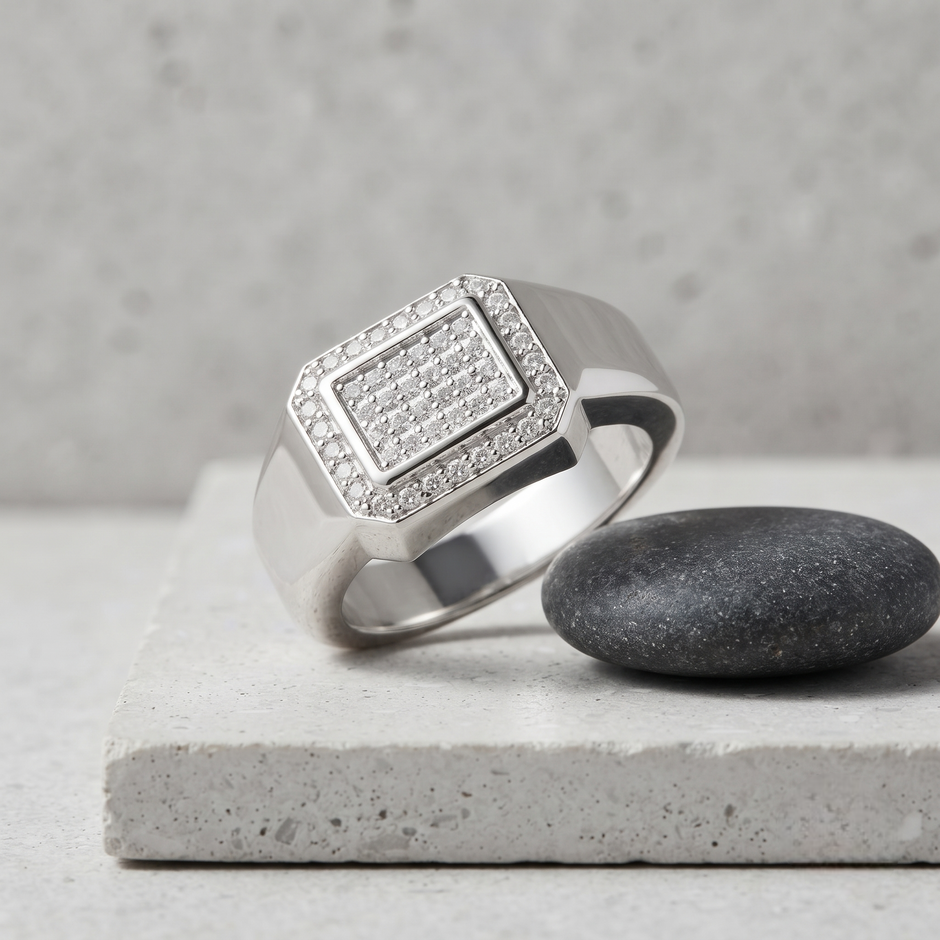Silver ring with a square pavé-set centre, stone-studded halo and wide polished band.