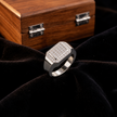 Silver ring with a square pavé-set centre, stone-studded halo and wide polished band.