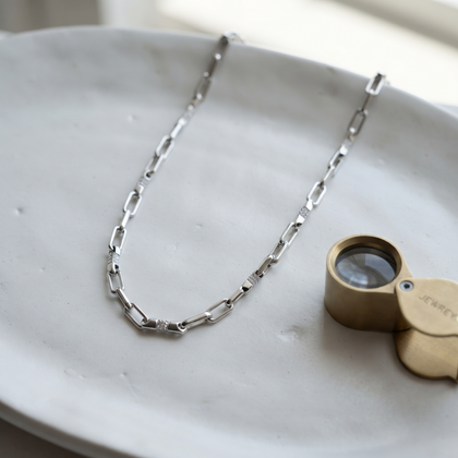 Silver rectangular-link chain with sparkling stone-set accents.