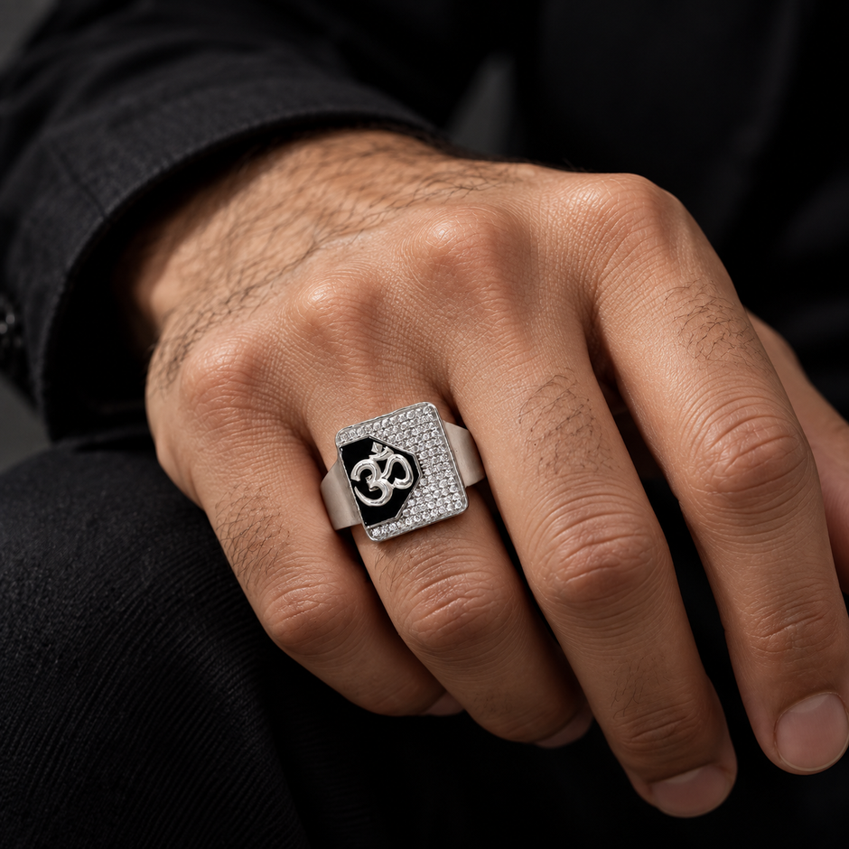 Silver ring with an Om symbol on a black centre and square stone-studded border.