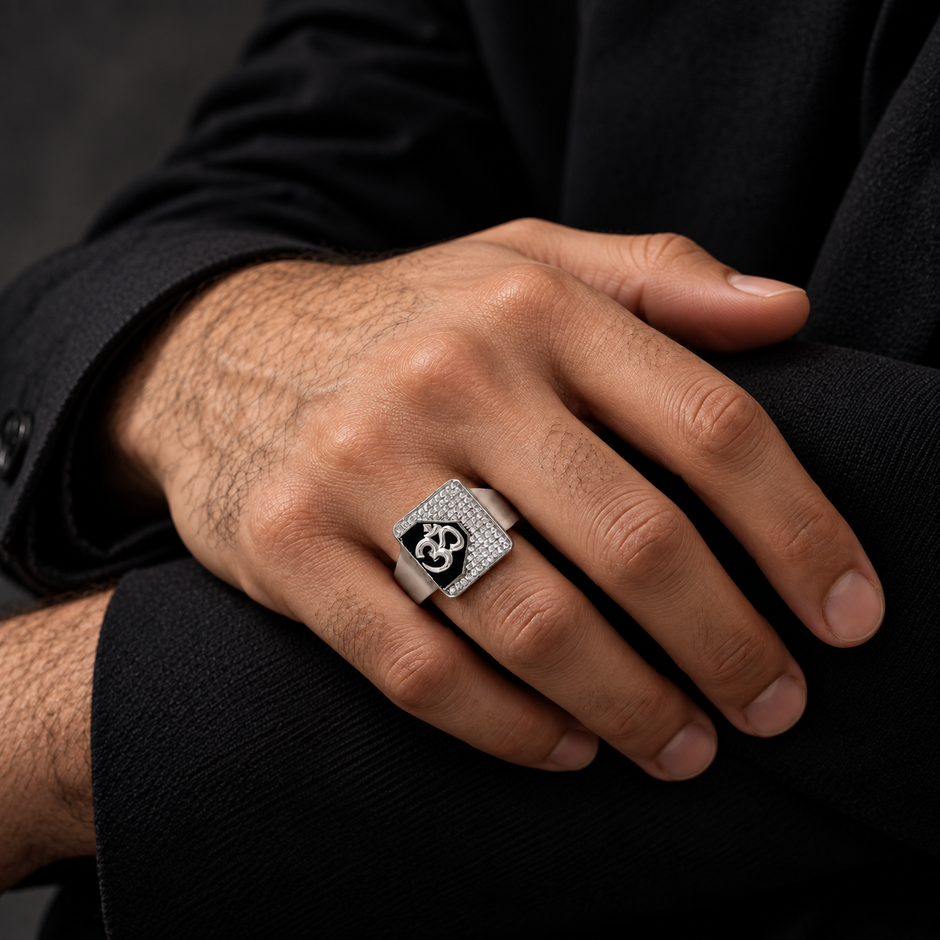 Silver ring with an Om symbol on a black centre and square stone-studded border.