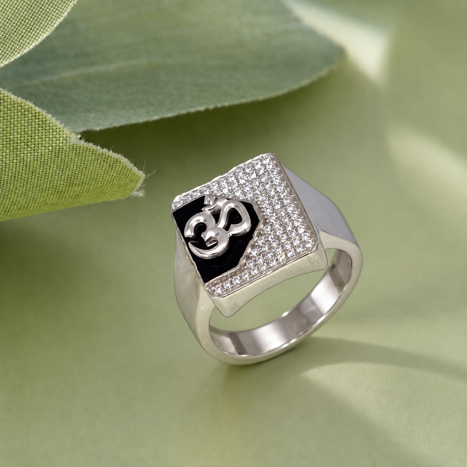 Silver ring with an Om symbol on a black centre and square stone-studded border.