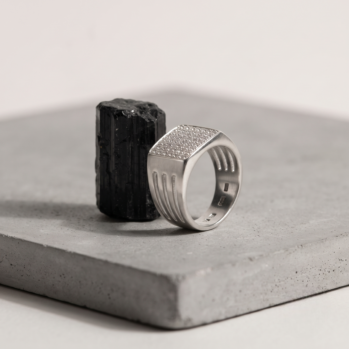 Silver ring with a square pavé-set face and open slotted band.