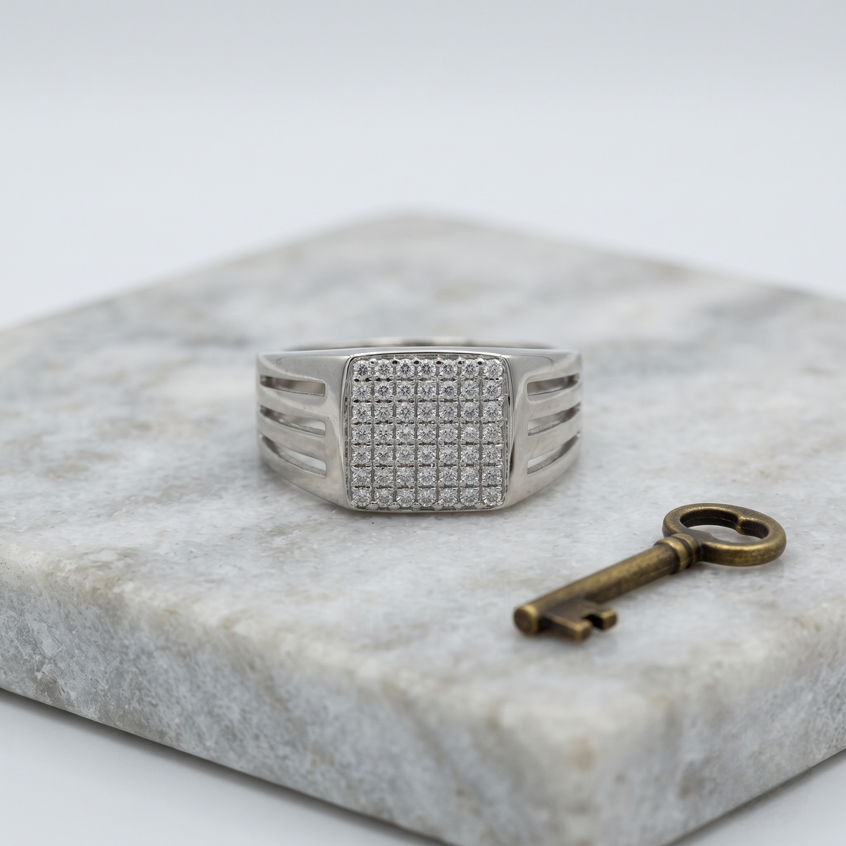 Silver ring with a square pavé-set face and open slotted band.