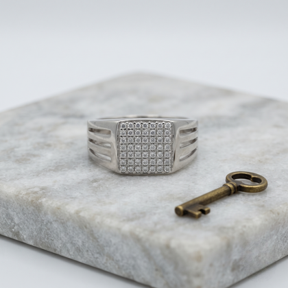 Silver ring with a square pavé-set face and open slotted band.