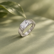 Silver ring with an emerald-cut clear solitaire stone and wide polished band.