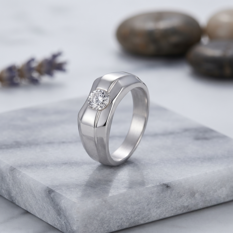 Silver ring with a round clear centre stone and a wide geometric band.