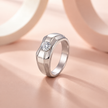 Silver ring with a round clear centre stone and a wide geometric band.