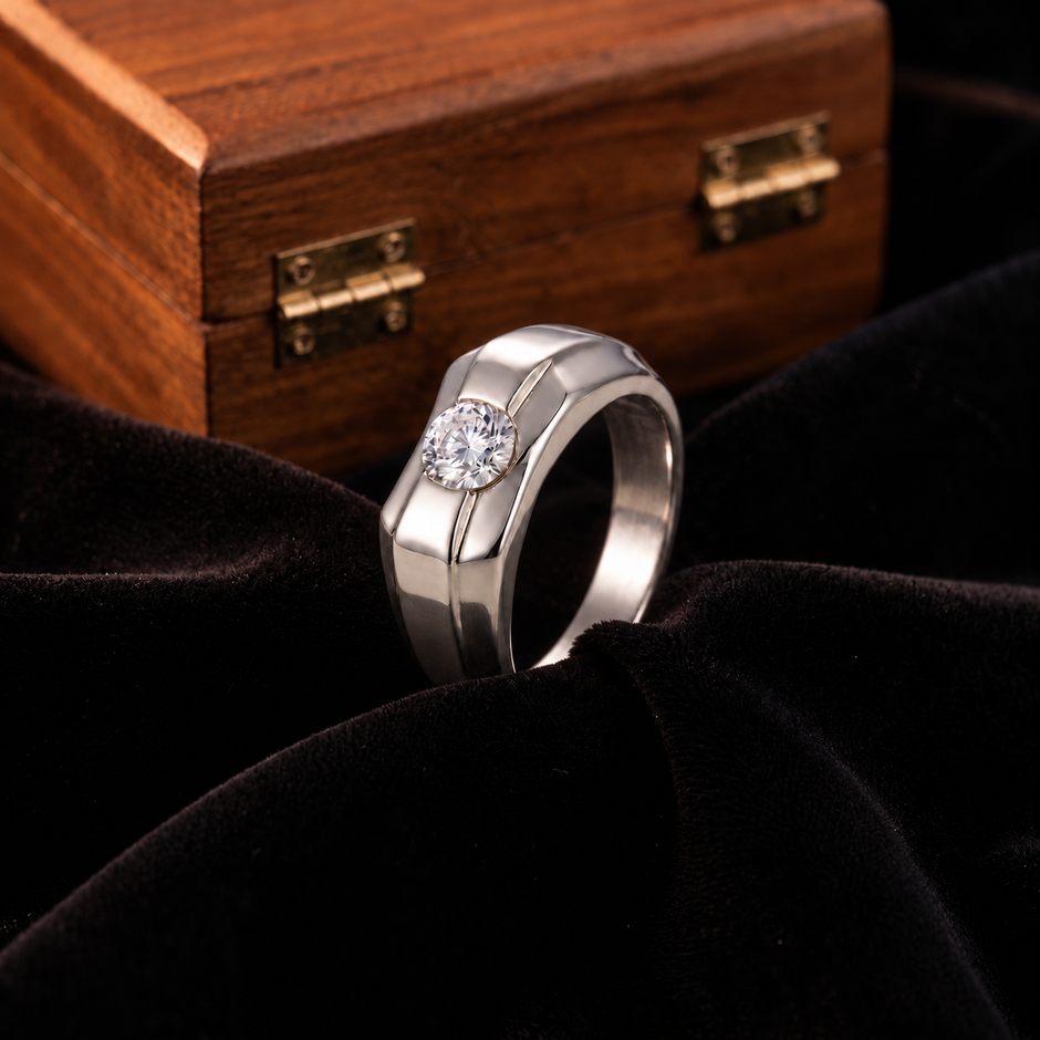 Silver ring with a round clear centre stone and a wide geometric band.