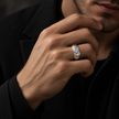 Silver ring with a round clear centre stone and a wide geometric band.