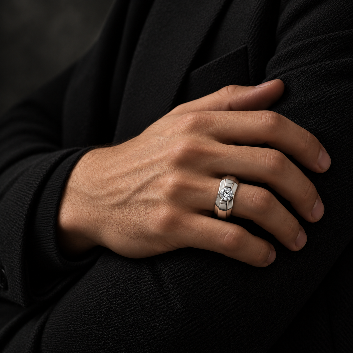 Silver ring with a round clear centre stone and a wide geometric band.