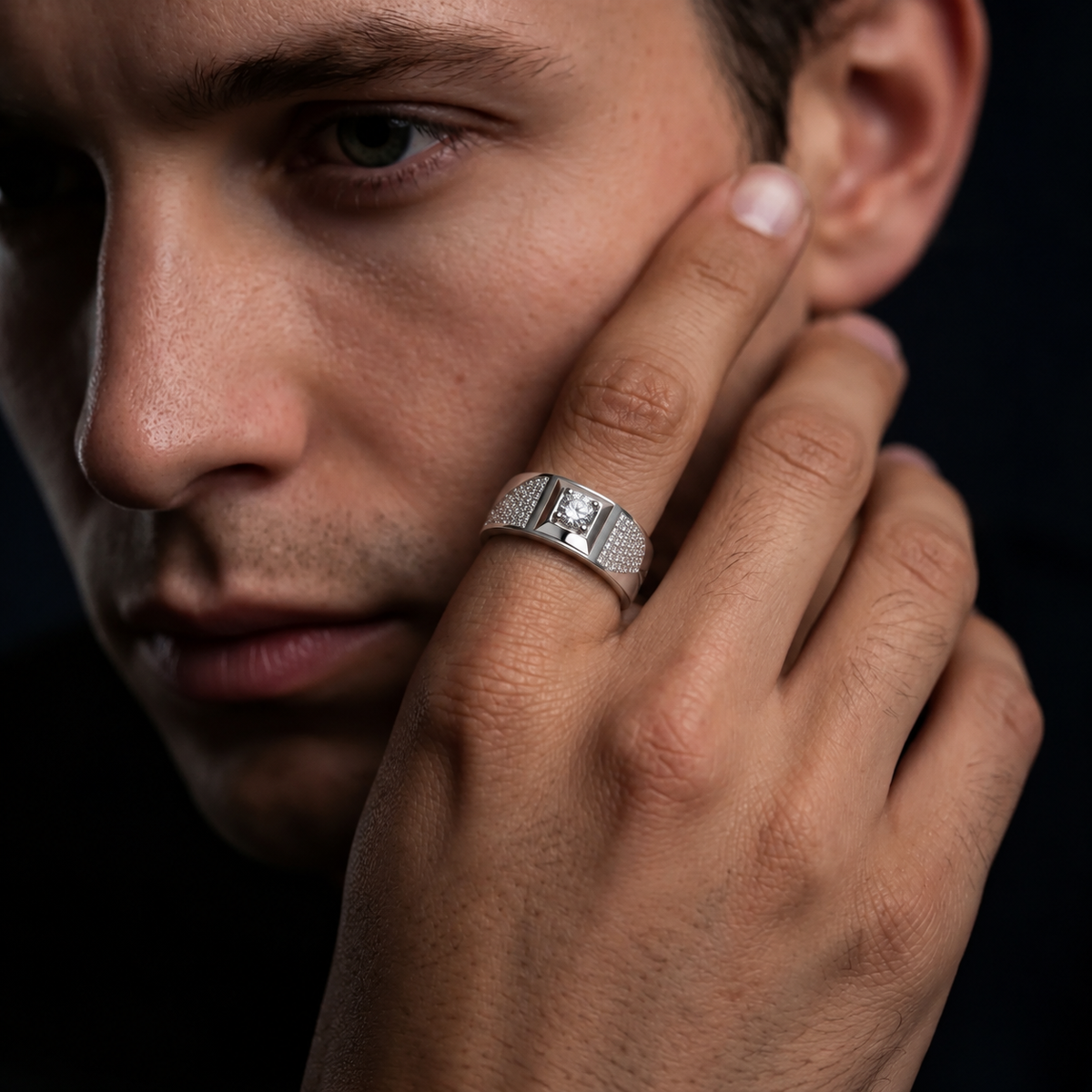 Silver ring with a round clear centre stone, square setting and pavé-set shoulders.