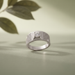 Silver ring with a round clear centre stone, square setting and pavé-set shoulders.