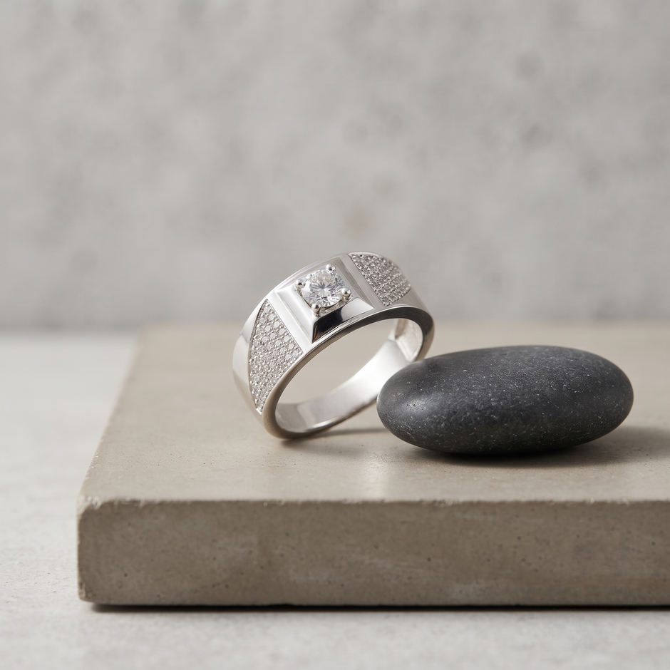 Silver ring with a round clear centre stone, square setting and pavé-set shoulders.