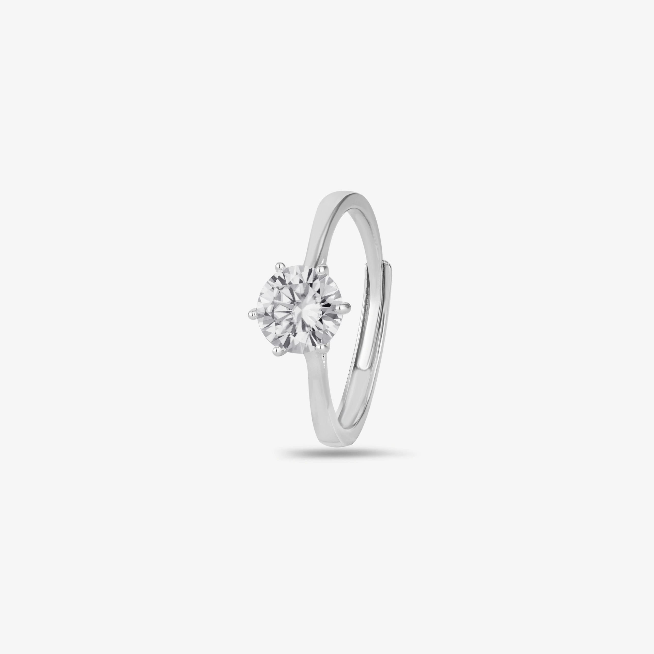 925 sterling silver solitaire ring with a round brilliant-cut stone, worn on a woman's hand against a soft white fabric background.