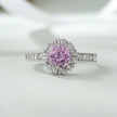 Ring with a pink diamond and diamond halo on a light background